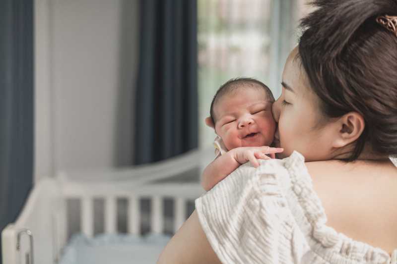 Mẹ dỗ bé sơ sinh đang khóc dạ đề