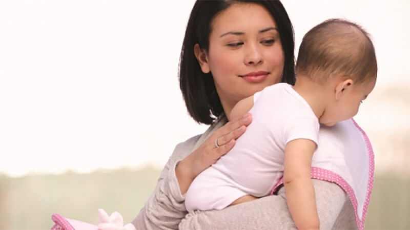 Mẹ bế bé dựa vào ngực và vỗ ợ hơi là cách để tránh trẻ sơ sinh bị đầy bụng