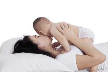 Mẹ bế và hôn bé